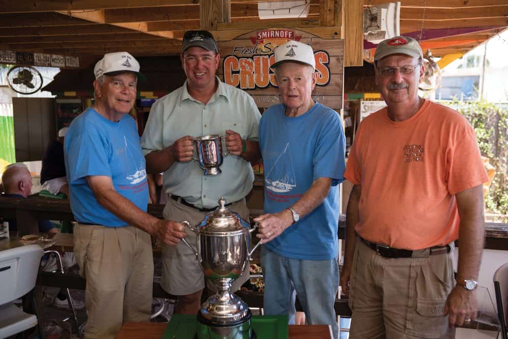    Ida May ’s captain and owners receive their trophies from Race Chairman Lou Hindman (right).  
