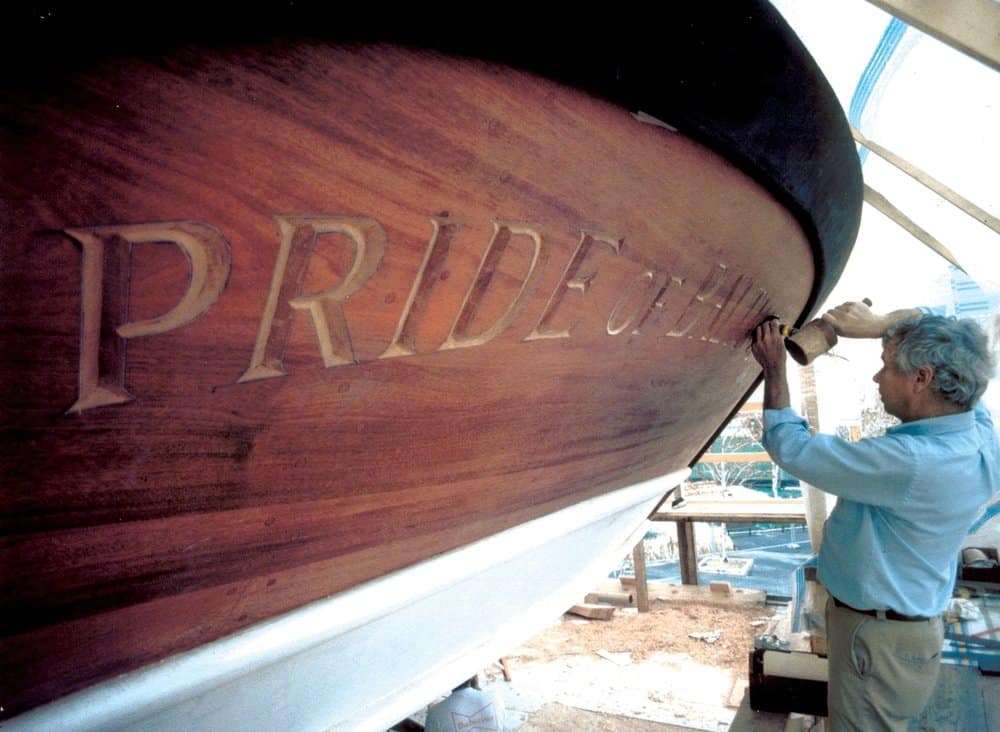  Hecklinger carving the name board on the original Pride. He also carved Pride of Baltimore II’s. Photo by Fred Hecklinger. 